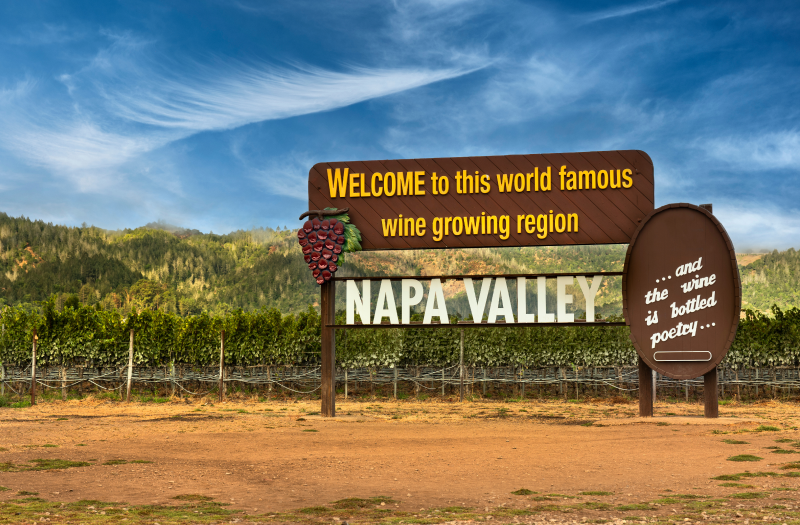 The Welcome to Napa Valley Sign along St. Helena Highway surrounded by vineyards.